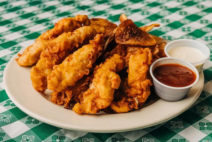 Product: A white plate with crispy chicken tenders, served with a small cup of ranch dressing and a side of ketchup - RJ Grunts in Lincoln Park - Chicago, IL American Restaurants