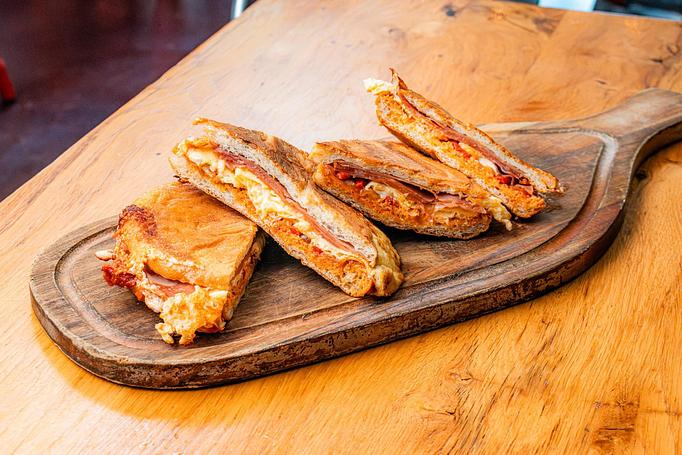 Product: Four triangle-shaped sandwich halves, with bright red and white filling on a wooden cutting board - Cafe Ba-Ba-Reeba! in Lincoln Park - Chicago, IL Gluten Free Restaurants