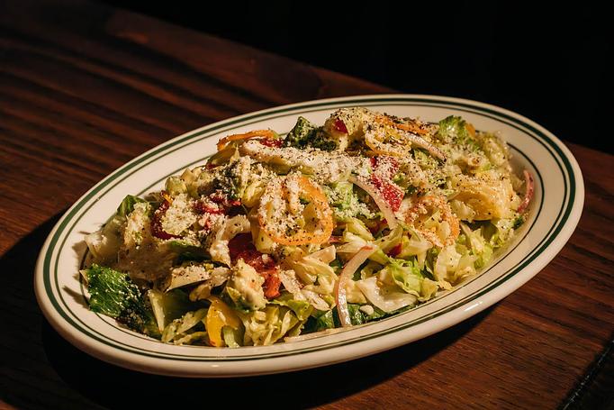 Product: A plate of chopped salad featuring lettuce, tomato slices, onions, pepperoncini, and grated cheese. - Gus' Sip and Dip in Chicago, IL Restaurants/Food & Dining