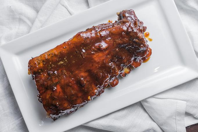 Product: Slow baked and topped with Black Rock BBQ sauce, served with your choice of one dinner side item. - Black Rock Bar & Grill in Orlando, FL American Restaurants
