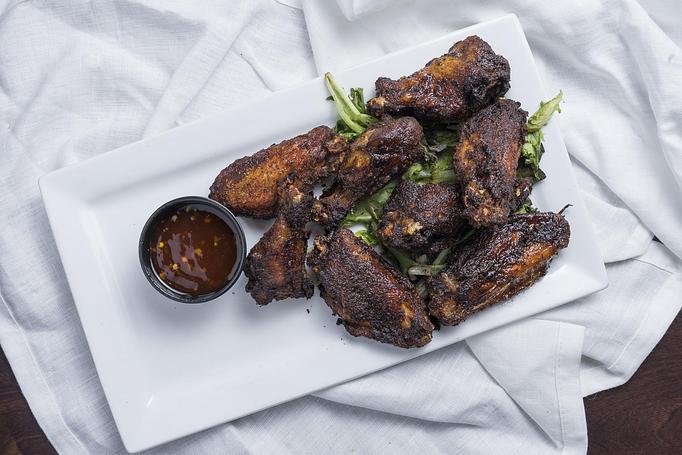 Product: A full pound of fresh, oven-roasted, jumbo Jamaican jerk rubbed wings, served with a sweet and spicy dipping sauce. - Black Rock Bar & Grill in Orlando, FL American Restaurants