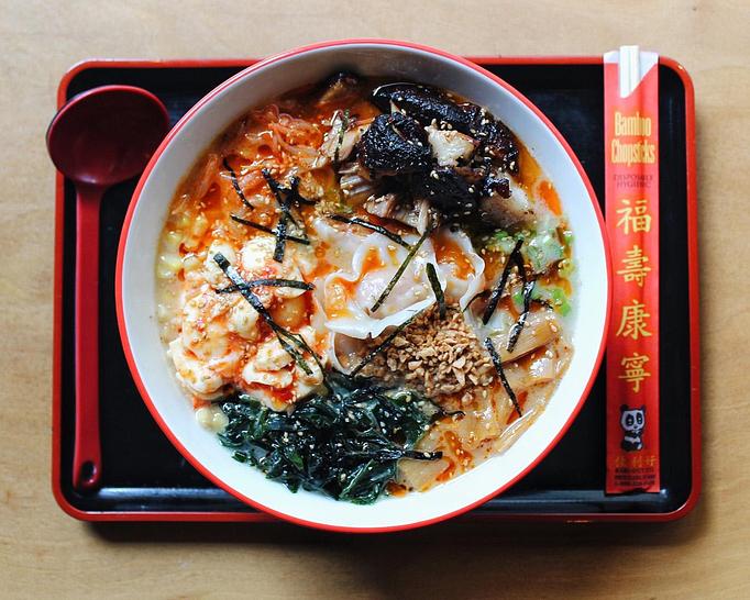 Product: a fully loaded ramen with pork broth, extra tokyo wavy noodles, green onion, 4 XO shrimp & pork dumplings, spicy bean sprouts, chasu pork, buttered corn, wakame seaweed, bamboo shoots, spicy crushed egg, fried garlic and sesame - RAMEN-SAN Whisky Bar in Fulton Market - Chicago, IL Japanese Restaurants