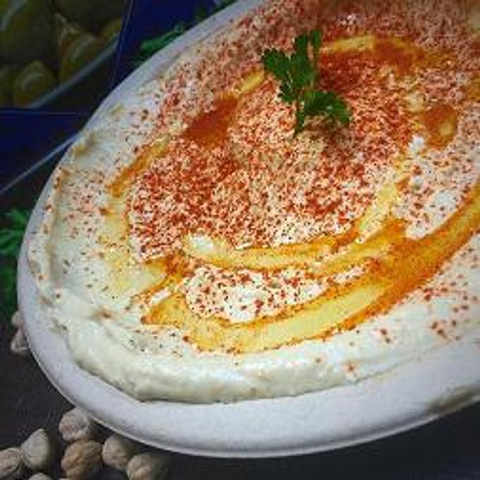 Product: Eight oz cup garbanzo beans pureed with tahini, lemon juice, spices, a touch of olive oil, served with two pitas - Rosemary Grill in Los Angeles, CA Mediterranean Restaurants