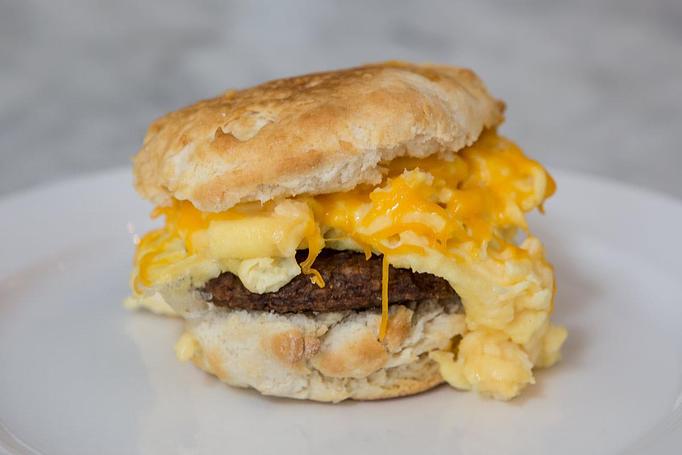 Product: Grilled breakfast sausage patty with one scrambled egg on a southern-style country biscuit.  
Tempt Restaurant - New Orleans French Quarter - Tempt in French Quarter / CBD - New Orleans, LA American Restaurants