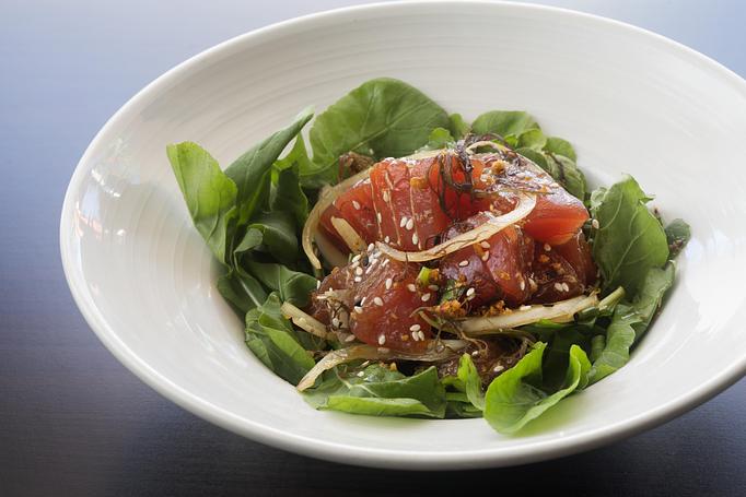 Product: Fresh yellowfin tuna cubed & seasoned with Hawaiian ogo seaweed, soy sauce & sesame oil. Served on a bed of organic baby arugula from the east side of Oahu. A local favorite! - Tikis Grill & Bar in Waikiki - Honolulu, HI Bars & Grills