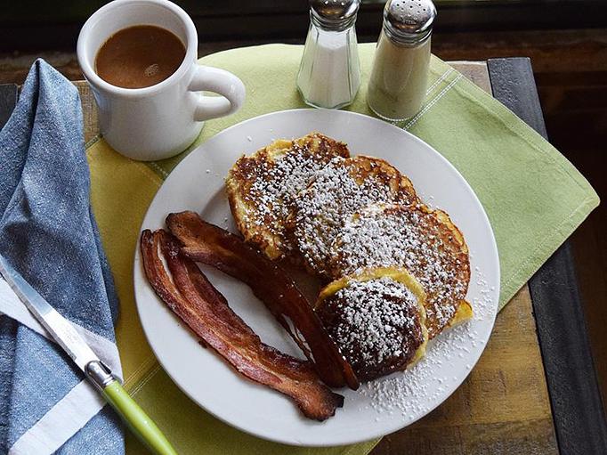 Product: Simma's French Toast - French toast made with Simma's Morning Buns served with Nueske's Bacon - West Allis Cheese & Sausage Shoppe in West Allis, WI Coffee, Espresso & Tea House Restaurants