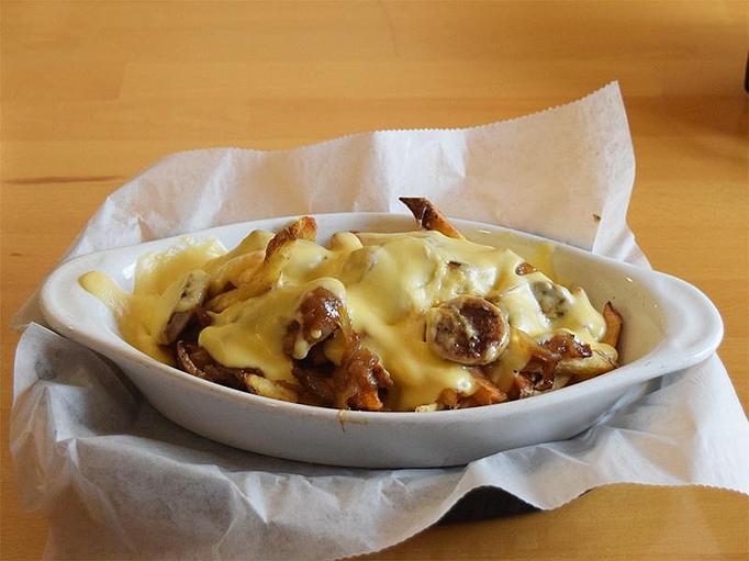 Product: Wisconsin fries - French fries topped with bratwurst, caramelized onions and cheese sauce - West Allis Cheese & Sausage Shoppe in West Allis, WI Coffee, Espresso & Tea House Restaurants