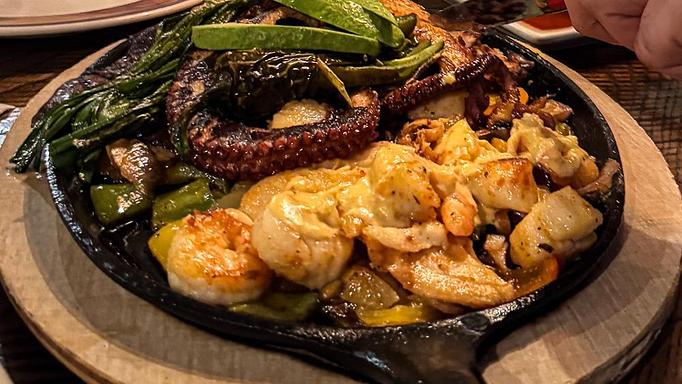 unclassified: Grilled octopus, shrimp, halibut, scallops, skirt steak, and chicken. Drizzled with delicious creamy lobster sauce. - Madaline's Grill & Steak House in Redmond, OR American Restaurants