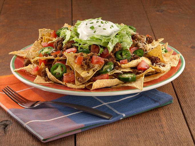 Product: A Paradiso classic! This party on a platter starts with a pile of chips, mild Cheddar and Monterey Jack cheese layered with your choice of meat, then baked. We finish this Mexican fiesta with jalapeños and a scoop of sour cream topping. - Paradiso Mexican Restaurant in Fargo, ND Mexican Restaurants