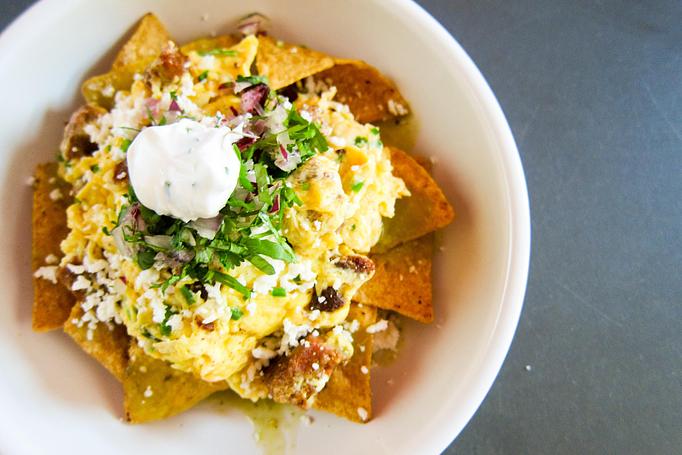 Product: melina's tortilla chips layered with house chorizo, scrambled eggs, salsa verde, cilantro, red onion, queso fresco & scallion sour cream - Southport Grocery & Cafe in Lakeview - Chicago, IL American Restaurants