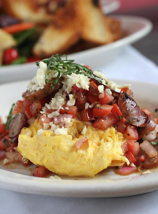 Product: crostini, scrambled eggs, chicken sausage, balsamic mix with red onion & local tomatoes, & queso fresco - Southport Grocery & Cafe in Lakeview - Chicago, IL American Restaurants