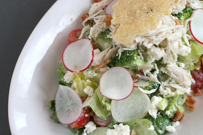Product: romaine lettuce, chicken, local tomato, pickled green  tomato, bacon, radish, cucumber, broccoli,
feta cheese  & parmesan crisps with our buttermilk
herb dressing - Southport Grocery & Cafe in Lakeview - Chicago, IL American Restaurants