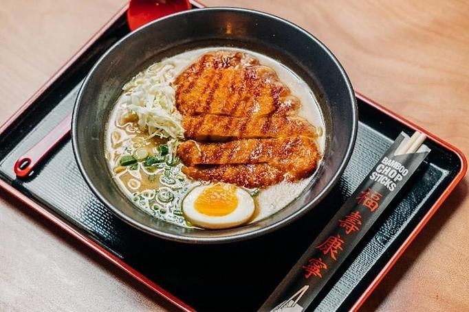 Product: a fan favorite, this bowl flaunts a savory mustard miso pork broth with our tokyo wavy noodles and topped with a fried pork cutlet, shredded cabbage, molten egg and a drizzle of mustard and bbq sauce - RAMEN-SAN Whisky Bar in Fulton Market - Chicago, IL Japanese Restaurants
