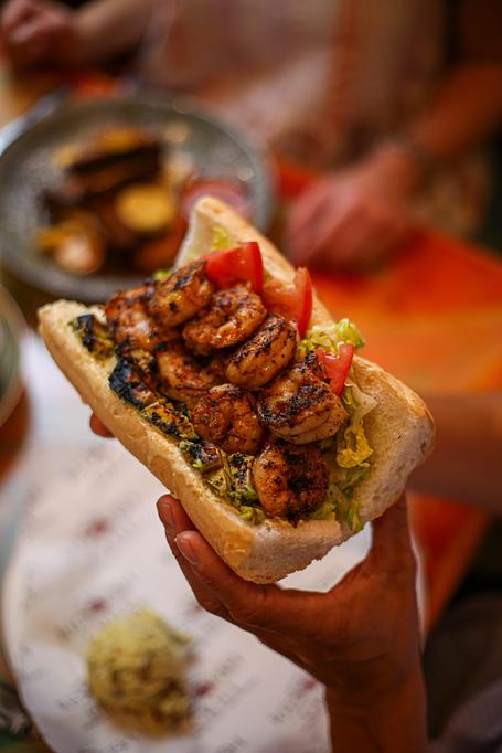 Product: Blackened Shrimp & Avocado Po-Boy - blackened Gulf shrimp, grilled avocado relish, smoked onion aioli,tomato, and lettuce, along with Creole potato salad - Red Fish Grill in French Quarter - New Orleans, LA American Restaurants