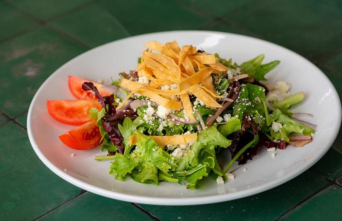 Product: Mixed greens, tomato, red onion, gorganzola cheese, corn strips, tomato-cilantro vinaigrette. - Red Mesa Restaurant in St Petersburg, FL Mexican Restaurants Product: Mixed greens, tomato, red onion, gorganzola cheese, corn strips, tomato-cilantro vinaigrette. - Red Mesa Restaurant in St Petersburg, FL Mexican Restaurants