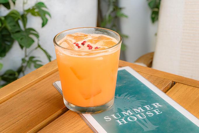 Product: Peach colored cocktail in a short glass of 818 blanco, passionfruit, and orgeat topped with pink peppercorn - Summer House - Las Vegas in Las Vegas, NV Restaurants/Food & Dining