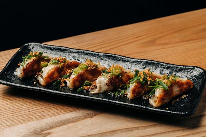 Product: 6 pan-fried gyoza, drizzled with wasabi soy and garnished with fried garlic and negi. - Sushi San - Reservations in River North - Chicago, IL Japanese Restaurants