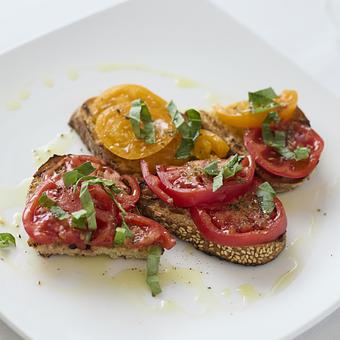 Product: House made Italian country sesame bread toasted with Market tomatoes and fresh basil - Angelino Restaurant in Sausalito, CA Italian Restaurants