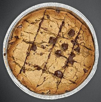 Product: Savor the irresistible delight of our Chewy Gooey Chocolate Chunk Pizza Cookie, a warm and inviting treat for the entire family. Crafted with Hershey's chocolate chips, each mouthwatering bite offers a perfect balance of chewiness and gooey richness - Brown Dog Pizza in Downtown Telluride, Main Street - Telluride, CO Bars & Grills