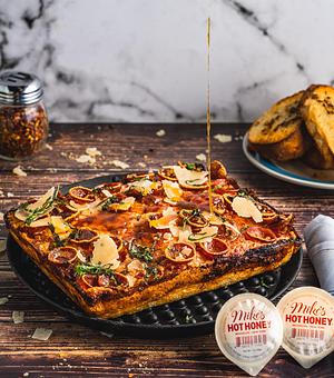 Product: Signature Pizza Sauce / Mozzarella / Cupping Pepperoni (Thick Cut) / Genoa Salami / Roasted Garlic / Fresh Basil / Parmesan Reggiano / Mike's Hot Honey - Brown Dog Pizza in Downtown Telluride, Main Street - Telluride, CO Bars & Grills