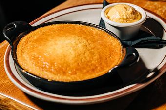 Product: Black skillet containing corn bread served on a white plate with a ramekin of honey butter - Bub City in Rosemont, IL Barbecue Restaurants