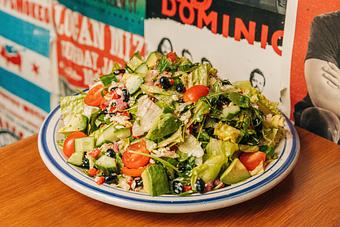Product: White bowl containing lettuce tossed in salad dressing and topped with tomatoes, black beans and avocado slices - Bub City in Rosemont, IL Barbecue Restaurants