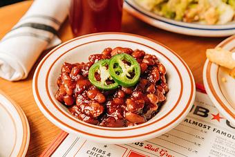Product: White bowl filled with baked beans topped with two slices of jalapeno - Bub City in Rosemont, IL Barbecue Restaurants