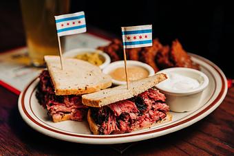 Product: Pastrami meat sandwich served on rye toast and cut in half with a Chicago flag toothpick suck through each half - Bub City in Rosemont, IL Barbecue Restaurants