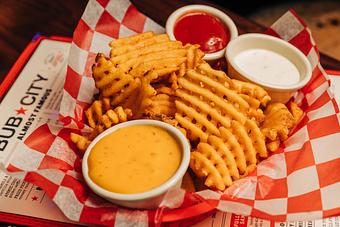 Product: Waffle-style French fries on a plate with cheese, ranch dressing and ketchup - Bub City in Rosemont, IL Barbecue Restaurants