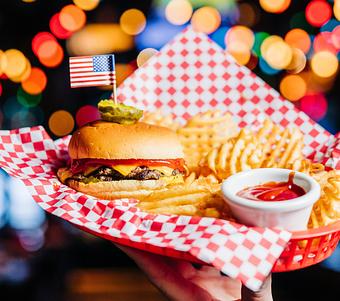 Product: Cheeseburger on a plate with red checkered tissue paper and waffle-style French fries - Bub City in Rosemont, IL Barbecue Restaurants