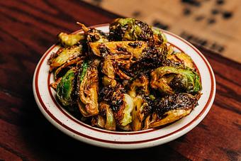 Product: White bowl filled with crispy Brussels sprouts cut into halves - Bub City in Rosemont, IL Barbecue Restaurants