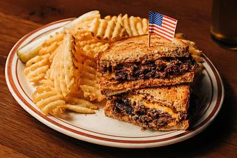 Product: Cheeseburger using rye bread toast as its bun served on a white plate with waffle-style french fries - Bub City in Rosemont, IL Barbecue Restaurants