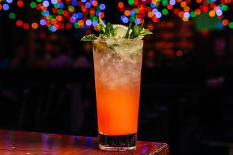 Product: Tall Collins-style cocktail glass containing a pink beverage with ice and topped with a lime slice and mint leaves - Bub City in Rosemont, IL Barbecue Restaurants
