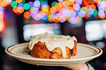 Product: cinnamon-roll served on a white plate and topped with melted cream cheese frosting running over the sides - Bub City in Rosemont, IL Barbecue Restaurants