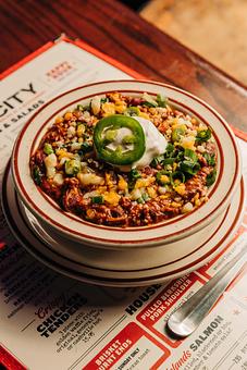 Product: Very full bowl of brisket chili topped with sour cream, cheese, chives and jalapeno slices - Bub City in Rosemont, IL Barbecue Restaurants