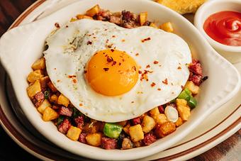 Product: White bowl filled with potatoes and vegetables and a fried egg on top - Bub City in Rosemont, IL Barbecue Restaurants