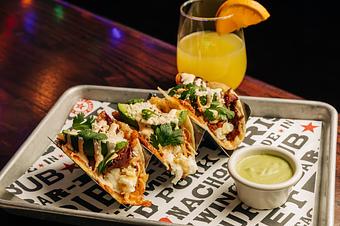 Product: Three breakfast tacos in metal taco holders resting on a plate - Bub City in Rosemont, IL Barbecue Restaurants