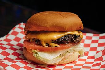 Product: Cheeseburger on a plate with red checkered tissue paper - Bub City in Rosemont, IL Barbecue Restaurants