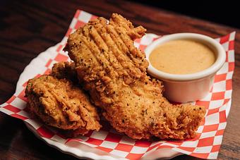 Product: Two breaded chicken tenders on a plate with a sauce - Bub City in Rosemont, IL Barbecue Restaurants