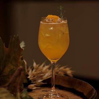 Product: A signature mocktail with orange juice, lemon, maple. Garnished with an orange slice and rosemary sprig - Chateau Faire Le Pont Winery in Wenatchee, WA American Restaurants