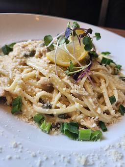 Product: Linguine, lemon pepper and caper sauce with Alaskan salmon, topped with parmesan. - Harvey's Grill and Bar in Saginaw, MI American Restaurants