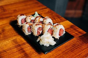 Product: nori seaweed wrapped with sushi rice, spicy tuna mix, siracha and chili oil. crusted with fried tempura bits and topped with japanese bbq sauce. sliced into eight pieces and served with soy sauce, pickled ginger and wasabi - Hub 51 in River North - Chicago, IL American Restaurants