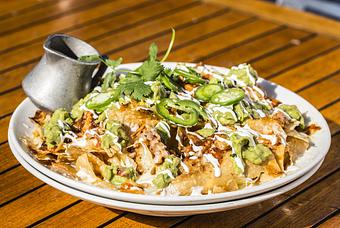 Product: an architectural wonder of all-natural chicken, guacamole, sliced jalapeños, cheddar and oaxaca cheeses, finished with sour cream and cilantro. served with roasted tomato salsa - Hub 51 in River North - Chicago, IL American Restaurants