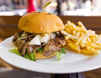 Interior: Marinated and grilled Tri-tip, caramelized onions, melted brie, crisp lettuce, soft grilled brioche bun, garlic aioli - Back Bistro in Palladio - Folsom, CA American Restaurants