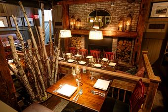 Interior: seating for larger parties near fireplace - Harrison's Restaurant & Bar in Stowe Village - Stowe, VT American Restaurants