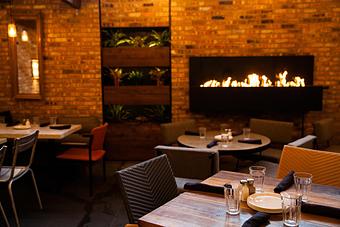 Interior: vintage brick patio with retractable roof and fireplace - Stella Barra Pizzeria & Wine Bar in Chicago, IL Pizza Restaurant