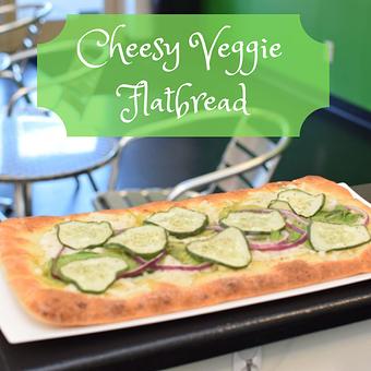 Product: This delicious vegan flatbread pizza has a basil pesto, vegan chees, cucumbers, spinach and onion. (Allergen warning: basil pesto is made with cashews) - Alkalicious Cold Pressed Juice Bar in Greenbrier East - Chesapeake, VA Organic Restaurants