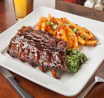 Product: A Whiskey's favorite. Slow cooked pork ribs chargrilled and basted with our honey whiskey BBQ sauce. Served with loaded french fries and BBQ slaw. - Big Whiskey's American Restaurant & Bar in Ozark, MO American Restaurants