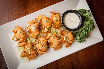 Product: Crispy fried wontons wrapped around pockets of Big Whiskey's Buffalo Chicken Dip and sprinkled with bleu cheese crumbles. Served with ranch dressing. - Big Whiskey's American Restaurant & Bar in Ozark, MO American Restaurants