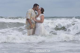 Product: Bride and Groom locked in a kiss, in the ocean amongst turbulent waves. - Billy Beach Photography in The Kerridor - Wilmington, NC Photography